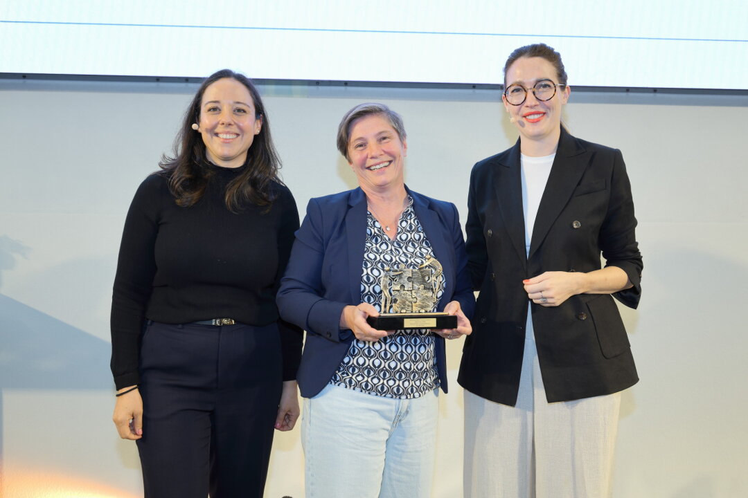 Drei Frauen stehen nebeneinander, die mittlere hält den Bavarian Best Practice Preis für die Geodigitalisierungskomponente in den Händen.